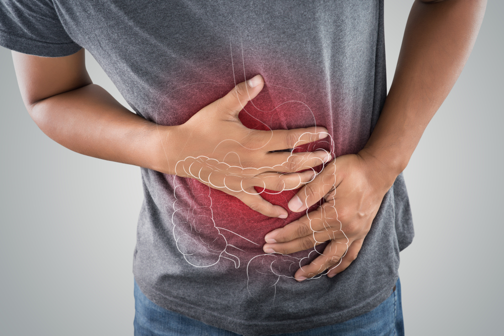 man holding stomach with IBS