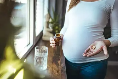 pregnant woman holding prenatals