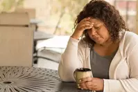 woman holding coffee feeling anxious