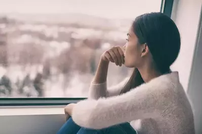 depressed woman staring out the window