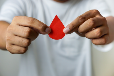 man holding drop of blood icon on paper