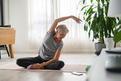 senior woman stretching on yoga mat