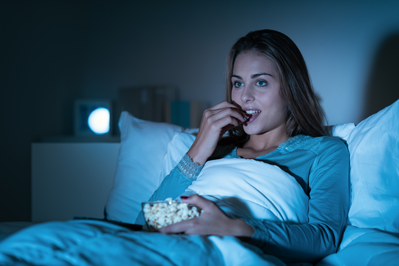 woman eating snack in bed