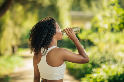 woman drinking water in park