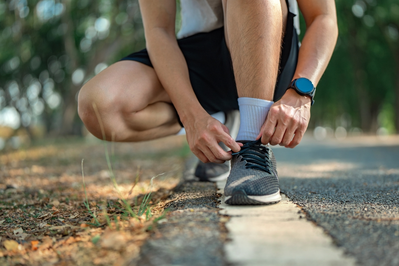 man tying running shoes