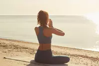 woman doing yoga on beach