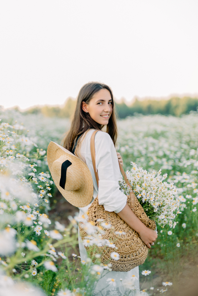 woman collecting white flowers in field