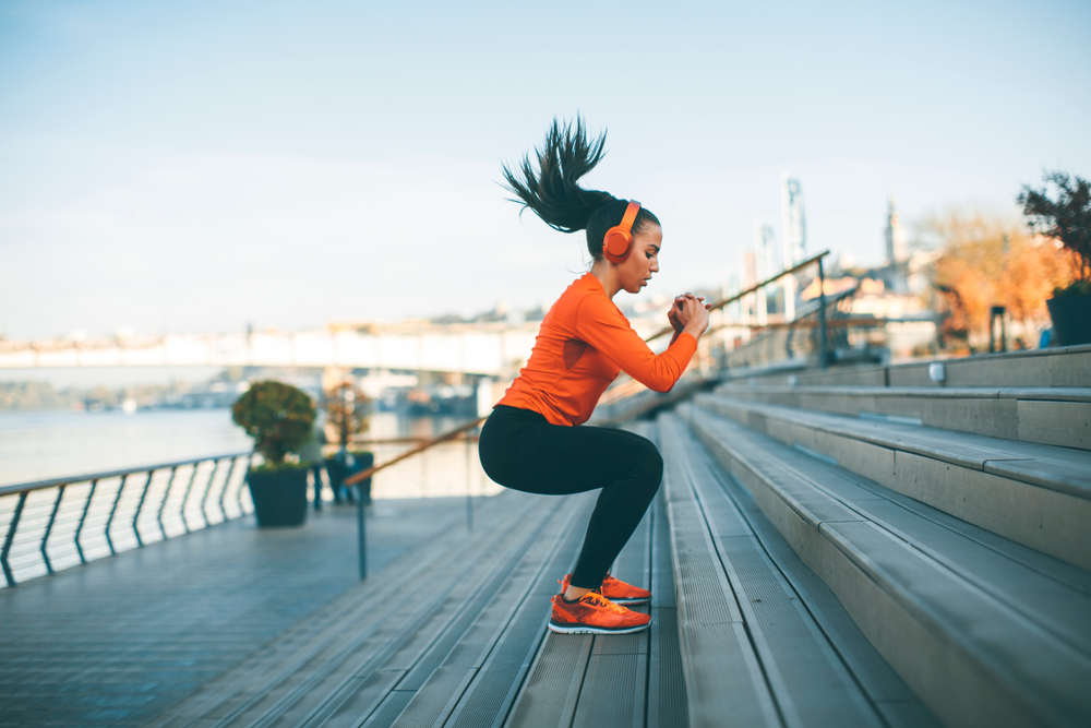 woman in workout gear jumping up steps